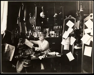 David Belasco in his study, leafing through a dictionary, 1909